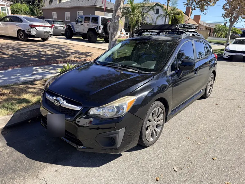 Black Subaru Impreza hatchback, front three-quarter view