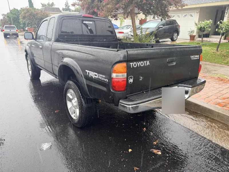 Black Toyota Tacoma TRD pickup, rear three-quarter view