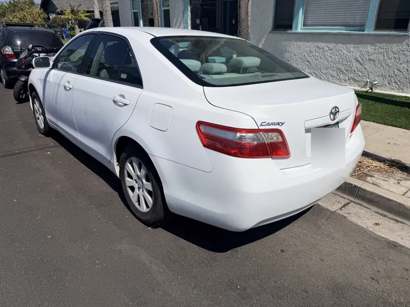White Toyota Camry, rear three-quarter view